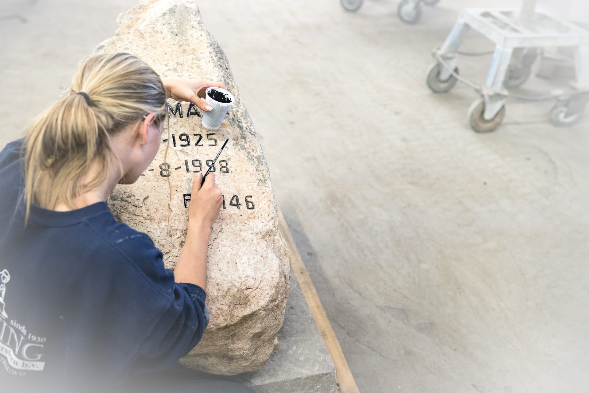 Grafsteen belettering in de werkplaats van Hutting Natuursteen