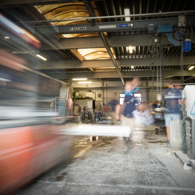 De grote werkplaats met bouwmachines van Hutting Natuursteen