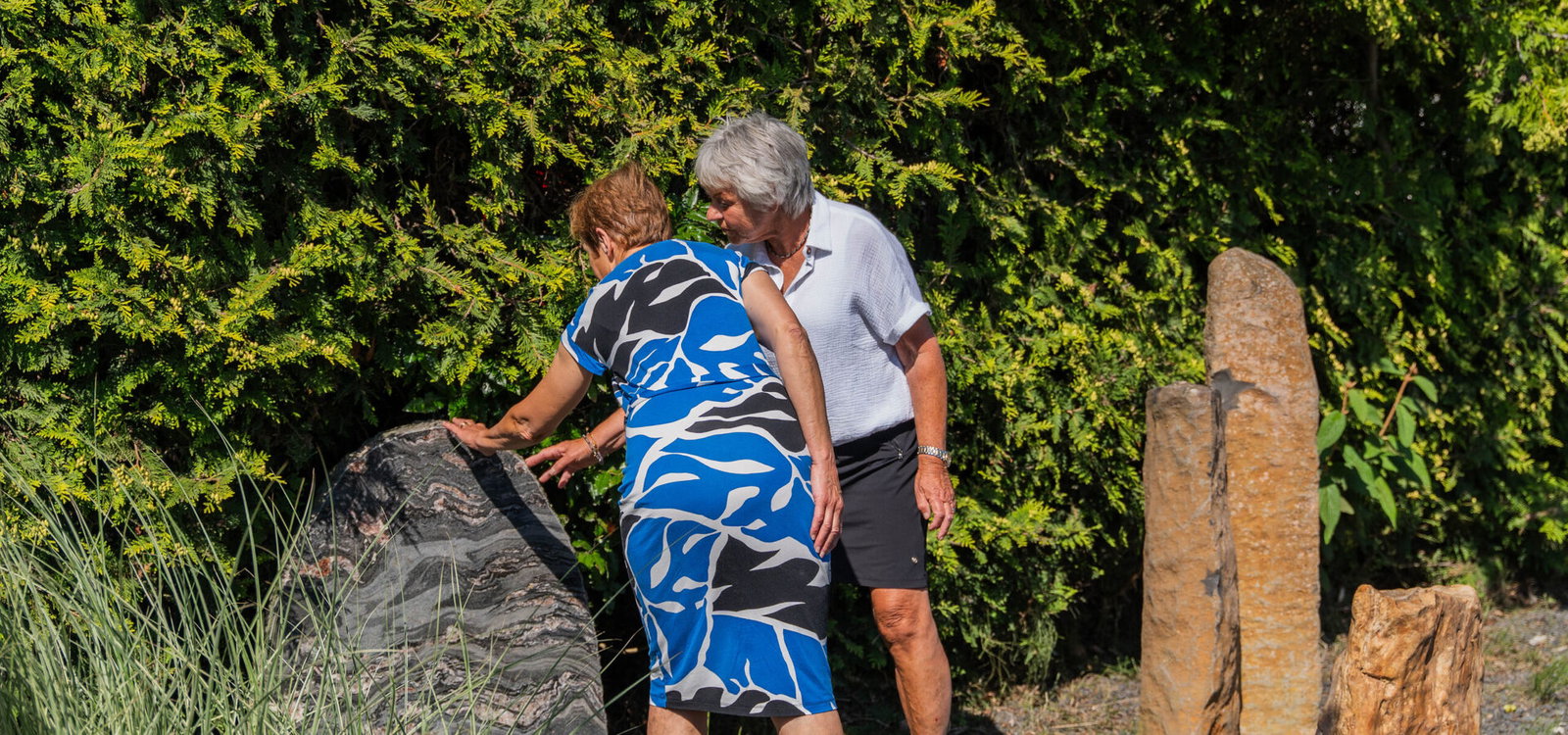 Adviseur en klant bekijken een liggende grafsteen