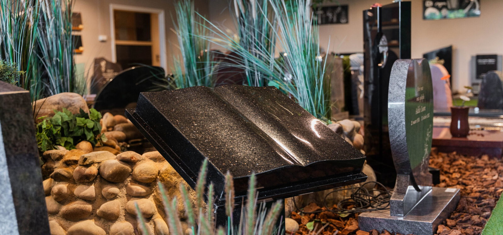 Liggende grafsteen van zwart graniet in de showroom